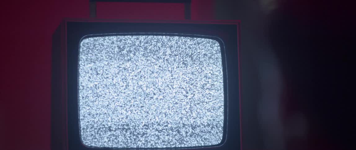 A person stares into a television filled with static