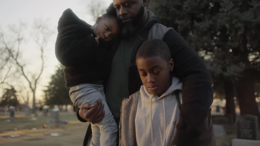 A family stands in the cemetery