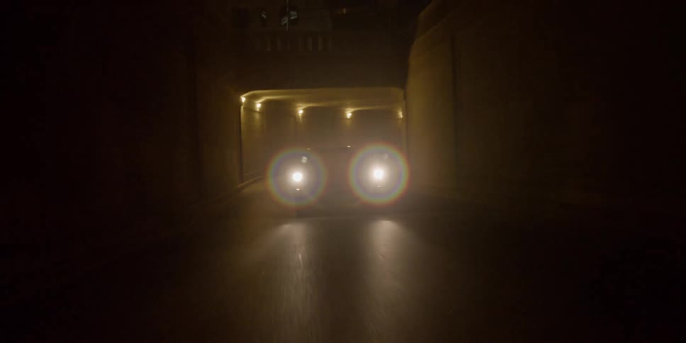 A car is driving through a tunnel at night