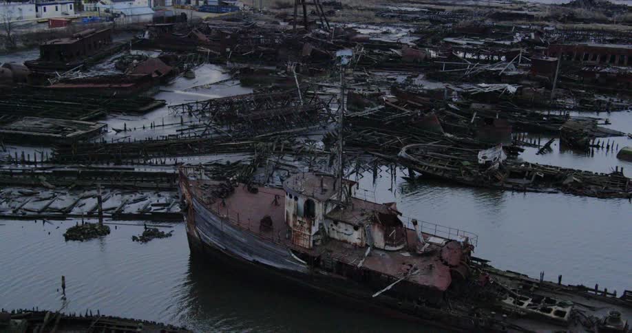 Numerous wrecked and rusting ships pushed into a shoreline