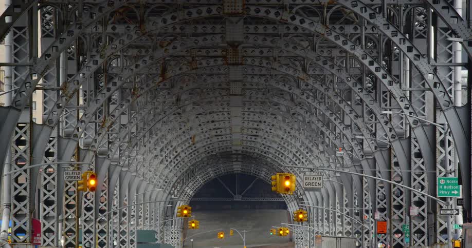 Street lights and signs under the arch of the harlem trestle