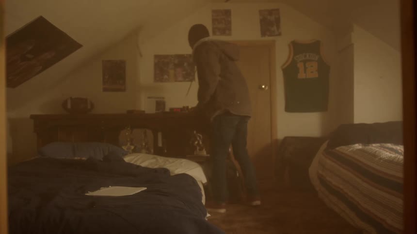 A man is putting on his coat in his bedroom