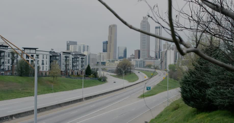 Cars drives along nearly empty highway leading from city