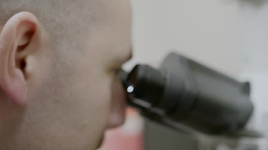 A man looks into a microscope