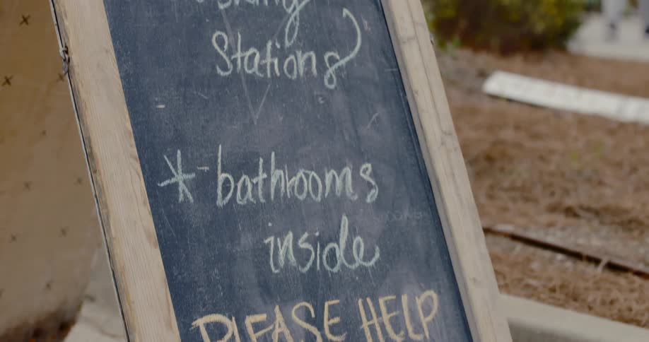 A chalkboard sign advertises washing availability outside of a building