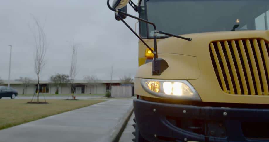 A school bus is parked at a curb