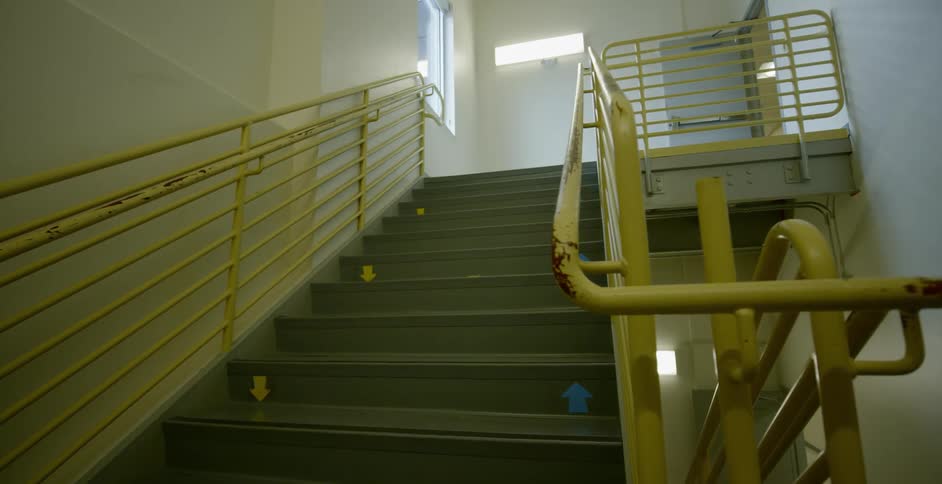 A staircase with yellow hand railings
