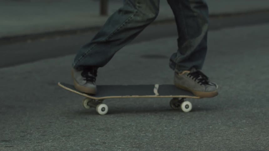 A tight shot of a skateboarder's feet and deck as he performs a trick