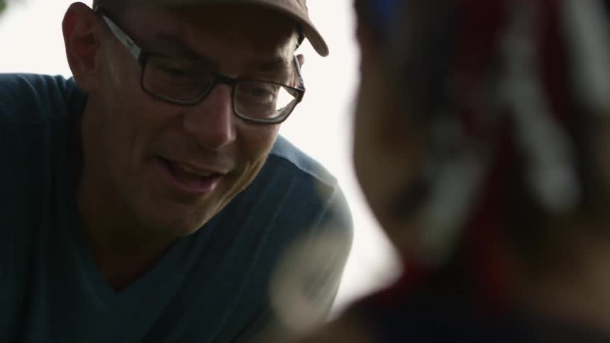 Man smiling and talking to another person