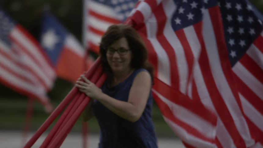 A woman gathers flags and walks away