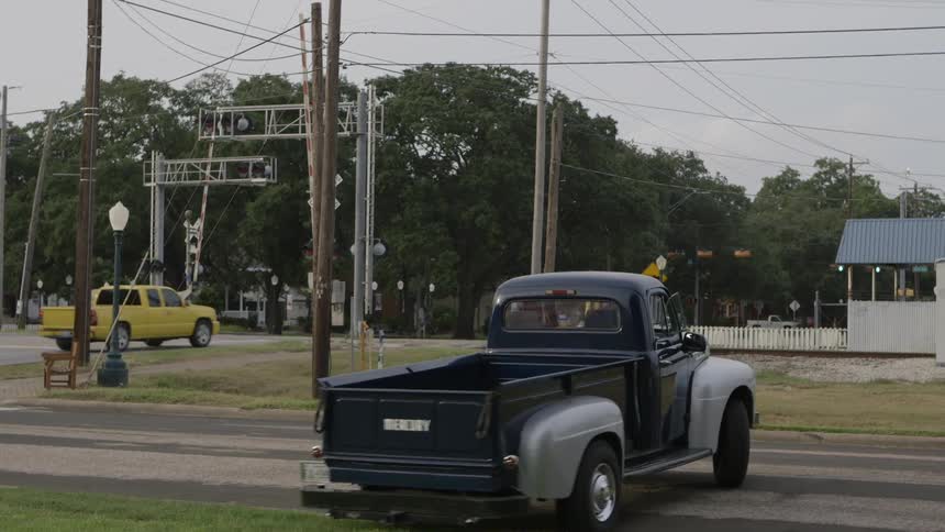 A pickup truck is pulling out onto a road on a cloudy day