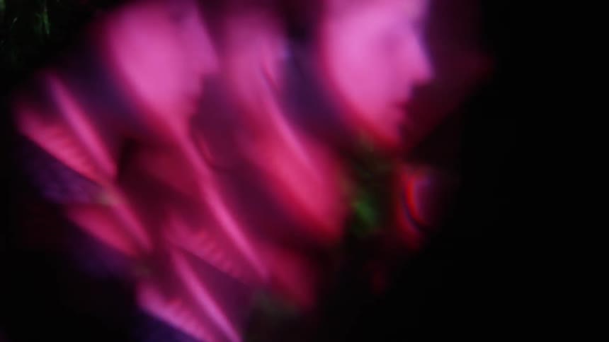 Colored lights strobe across a boy's face and create a kaleidoscope  effect