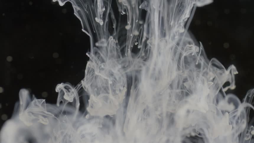 Abstract view of white liquid sinking in to a clear liquid