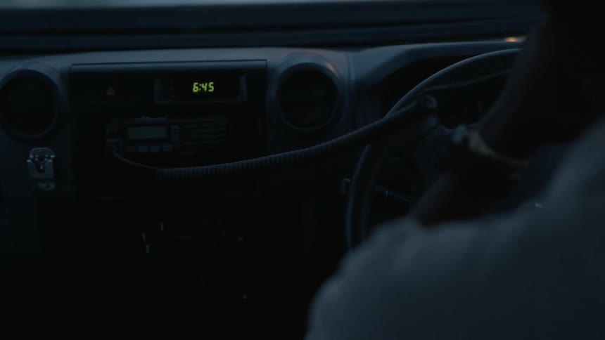A driver of a vehicle picks up a walkie hand held and speaks into it