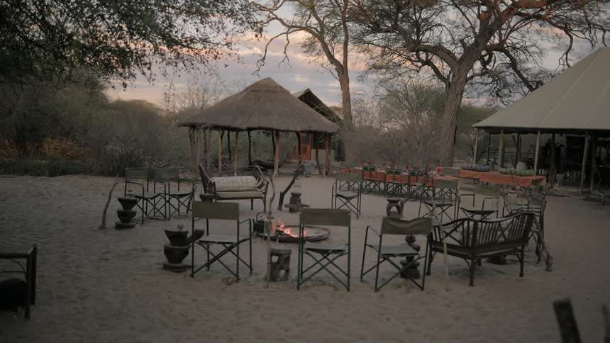 Small huts on hotel outdoor patio with chairs around a fire