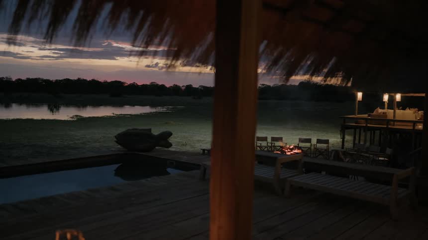 The resort with a jacuzzi a fire pit and chairs
