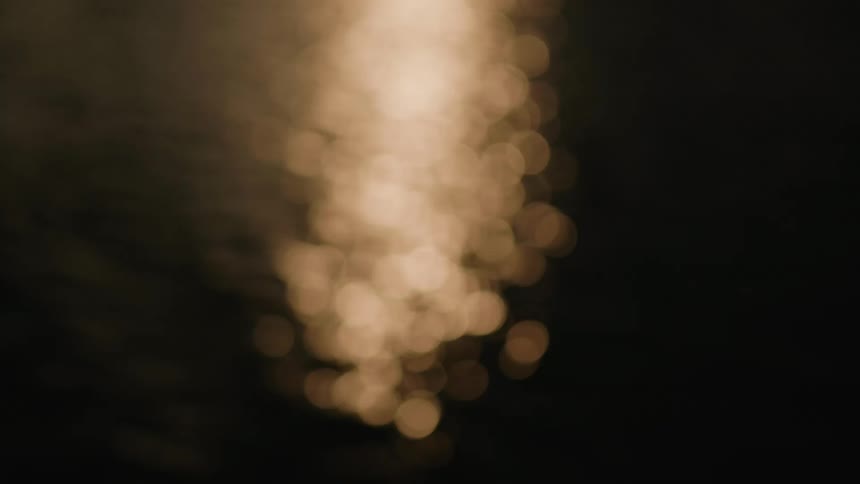 An unfocused aerial view of an ocean with bokeh lens effects