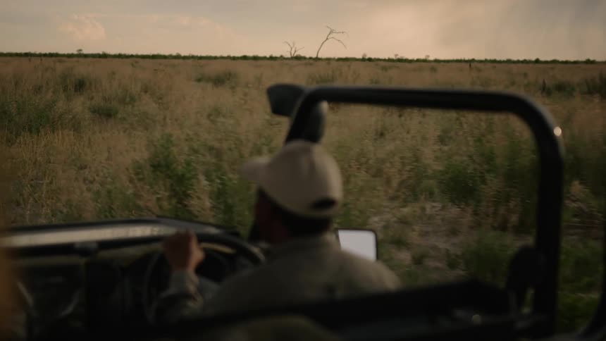 A man drives his vehicle through a grassy area