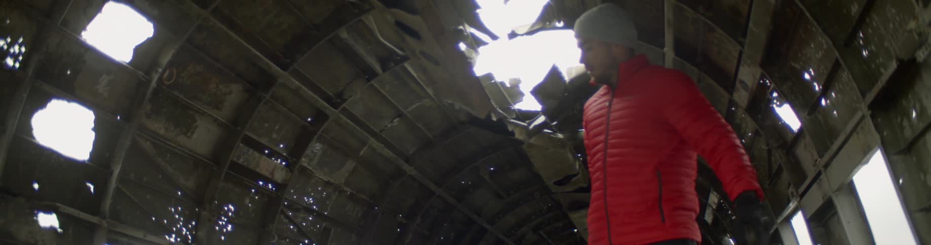 A man carrying a camera walks through an old building