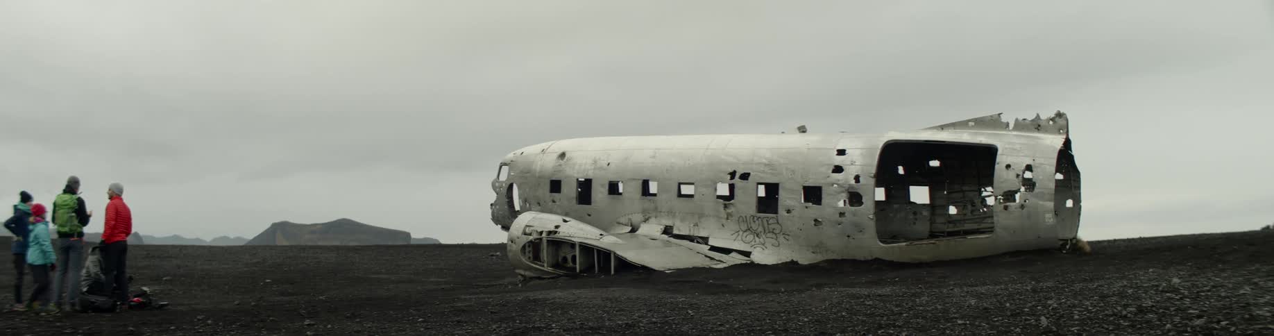 People stand outside the remains of a crashed airplane