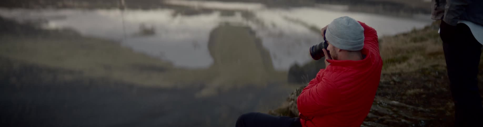 A man is taking photographs from on a hill