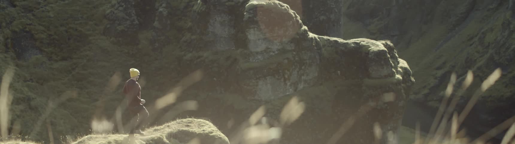 A man walks towards the edge of a cliff