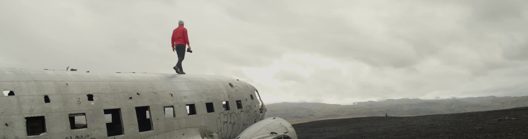 A man is walking on a crashed plane