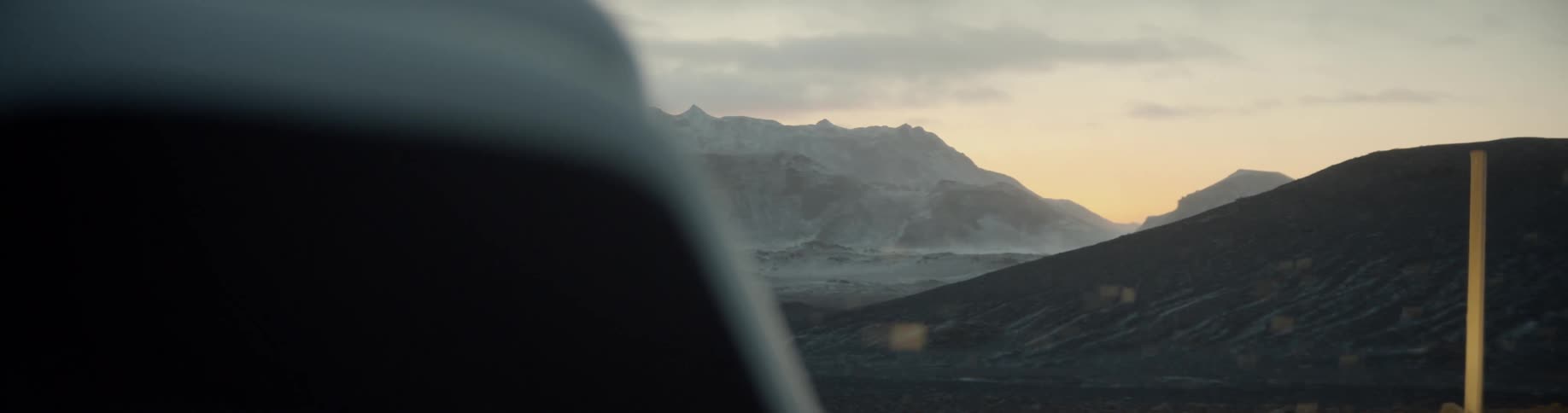 Wind blowing leaves through the air as a a mountain looms in the distance