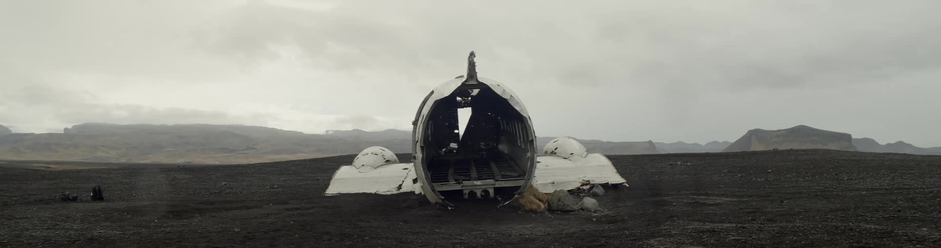View of touristic plane wreck on black sand on a cloudy day