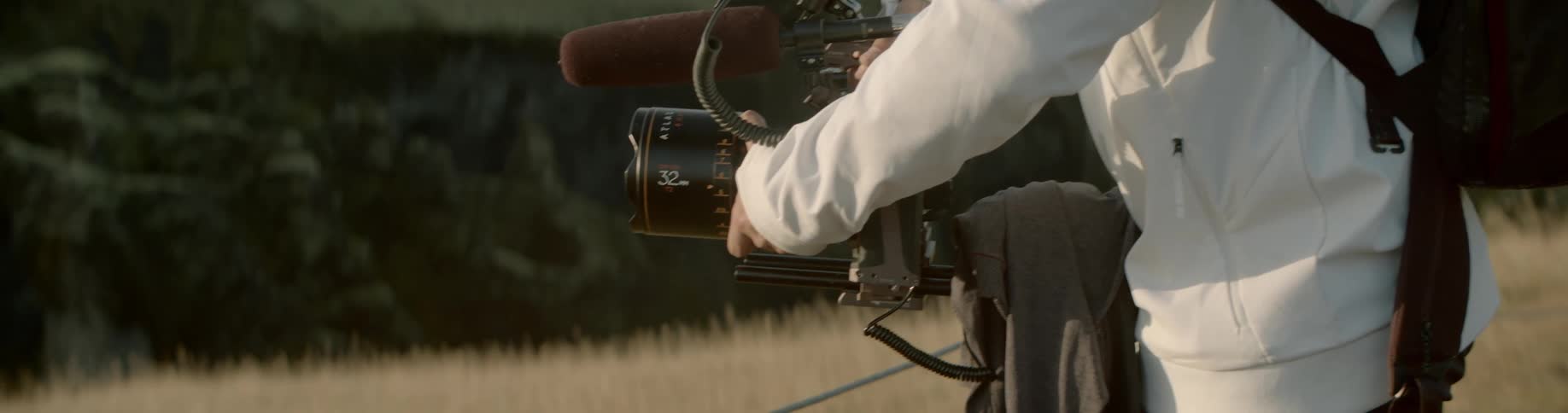 Photographer stands outdoors in field photographing