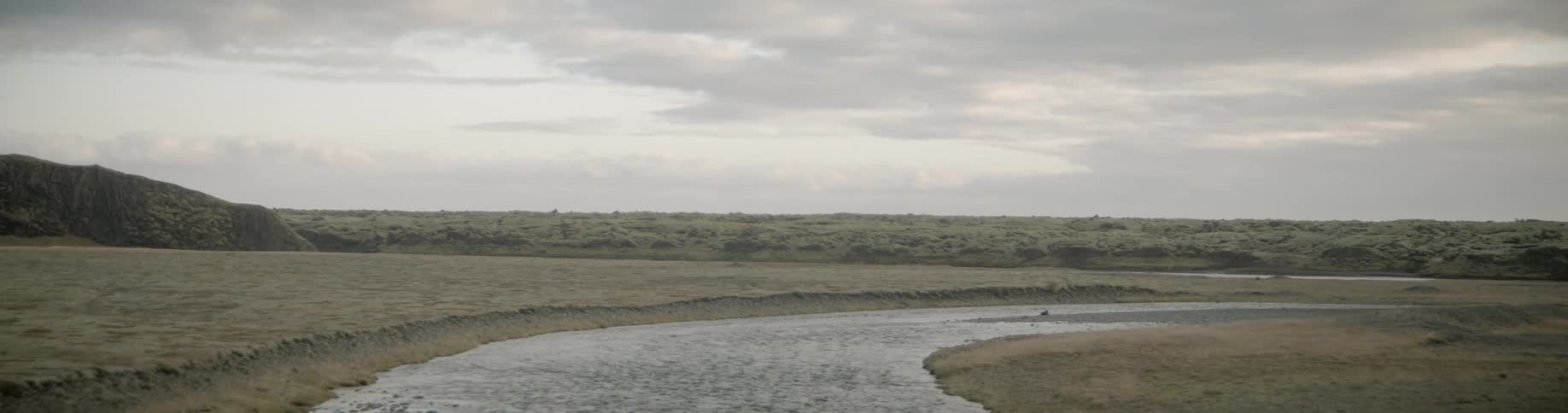 A shallow stream curves through rocky barren land