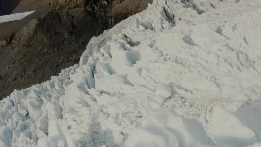 An aerial view of a glacier and mountains during the daytime