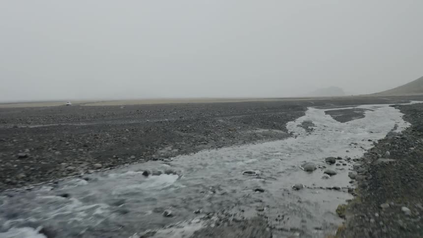 Streams of water flow along criss crossing veins through a desolate and rocky landscape
