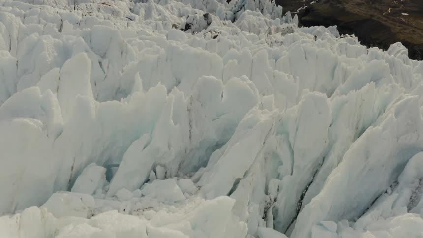 Craggy peaks decorate glacier topping mountain over valley