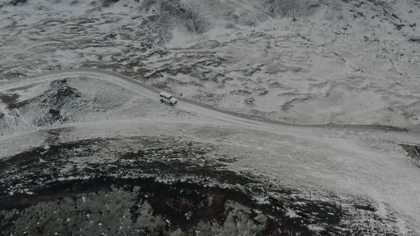 Birds eye view of a vehicle driving through a rocky area