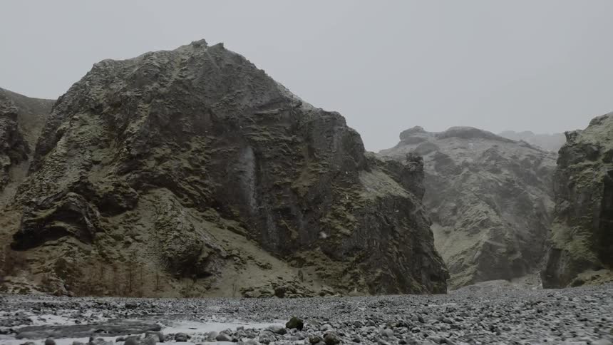 Snow falls over rock formations