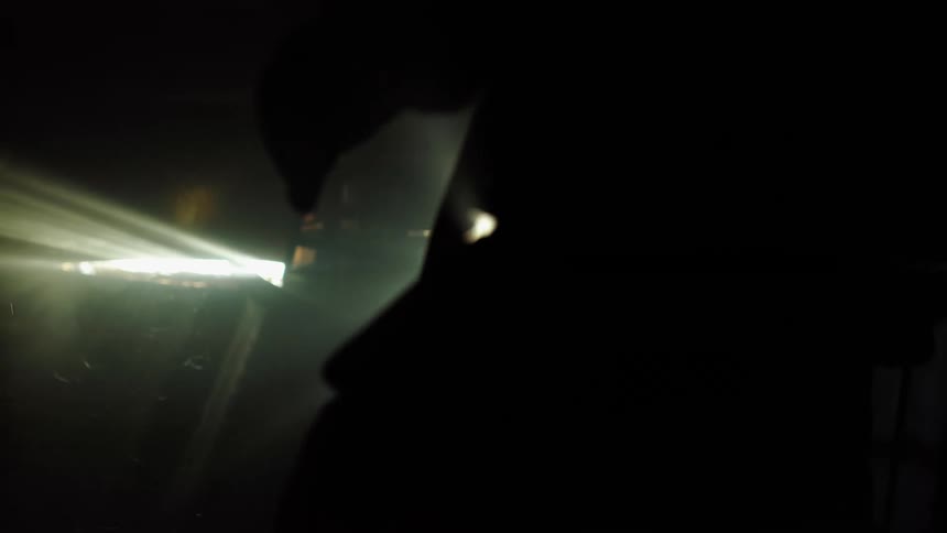 Firefighters stand in front of a beam of light at night