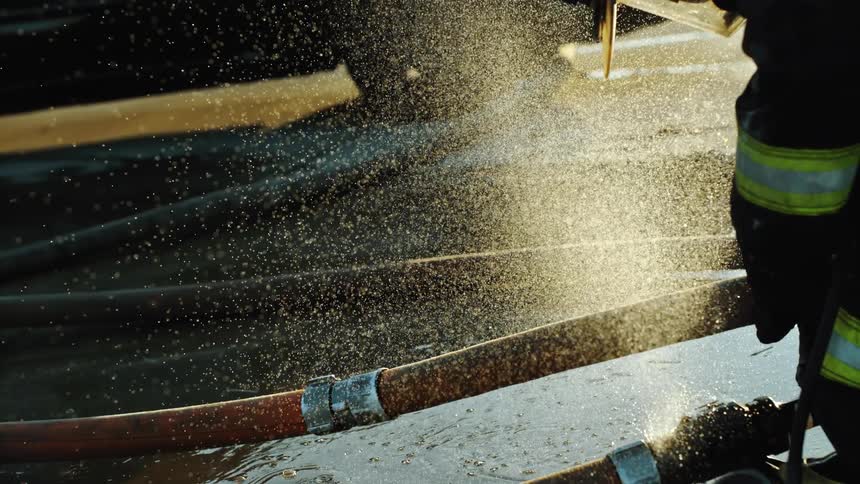 A firefighter sprays water from a hose