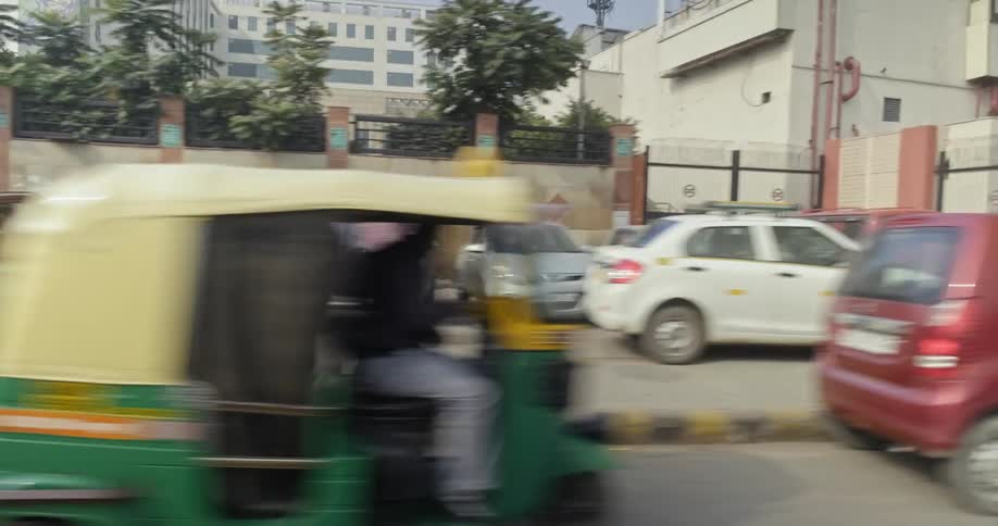 Rickshaws and motorcycles line the streets of delhi india during rush hour