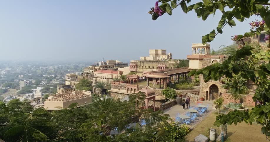 People walk in a pavilion on a hill in a third-world palace