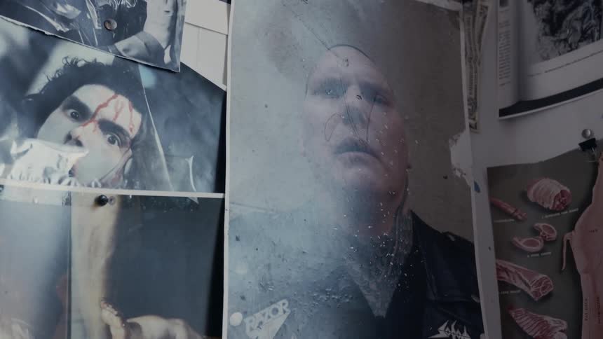 Posters of people with blood on their faces hang on a wall