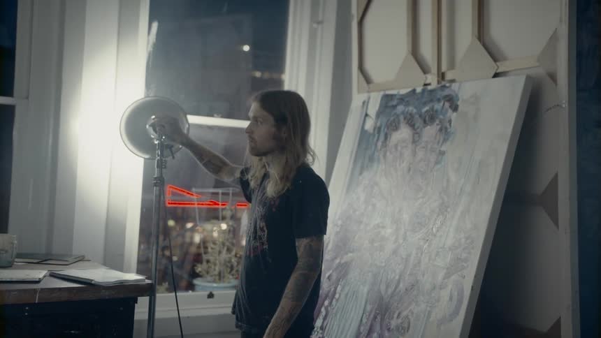 A man shines a large spotlight around a room