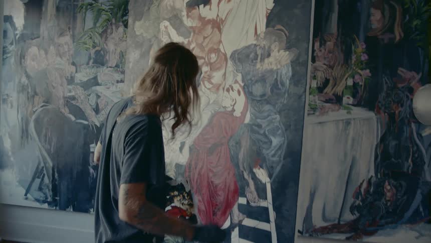 A man painting on a canvas with a paintbrush