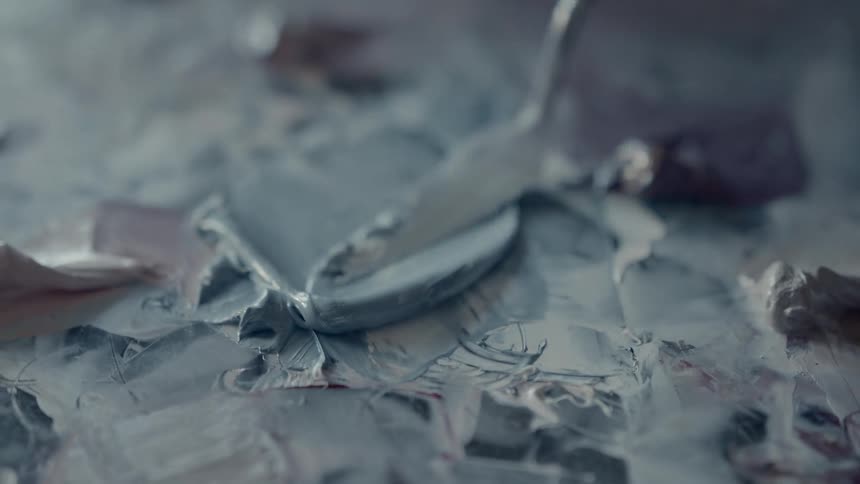 Close up of frosting being spread on a cake with a narrow spatula