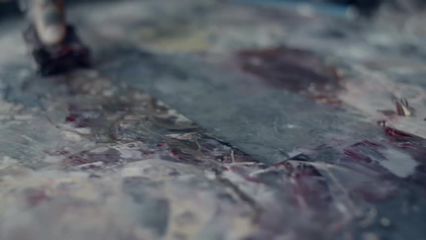 A person scraping wax off of a surface