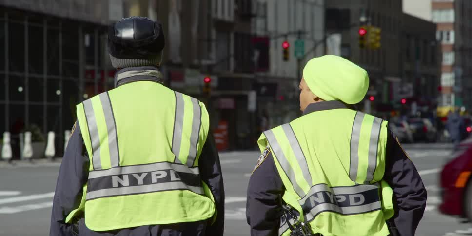 Police stand at a corner on a busy street