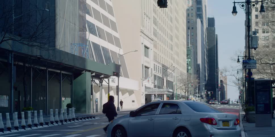 Car turns onto street at intersection in large city