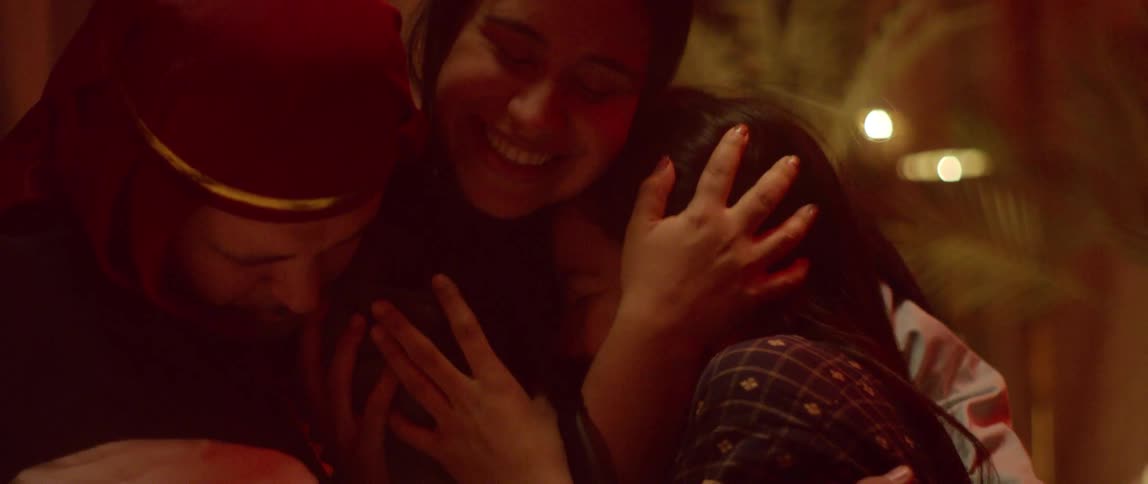 Two adults hug a younger child while dressed in costume