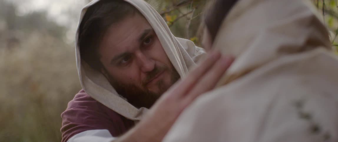 Man in costumes rub something on another mans face