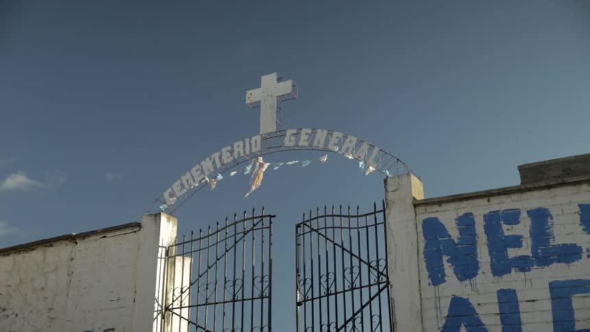 View of cemetery gates as the pennant flags above them flap in the breeze